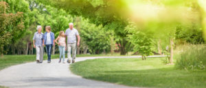 Senior couple walking outdoors with grandchildren