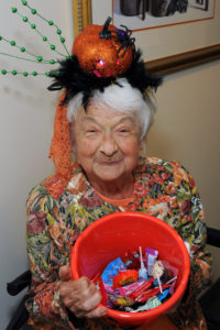 Decked out in Halloween finery, resident Julia Sullivan is ready to give out a bucket of Halloween candy.