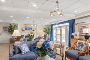 common living area with comfortable chairs and blue and white floral arrangements
