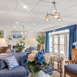 common living area with comfortable chairs and blue and white floral arrangements
